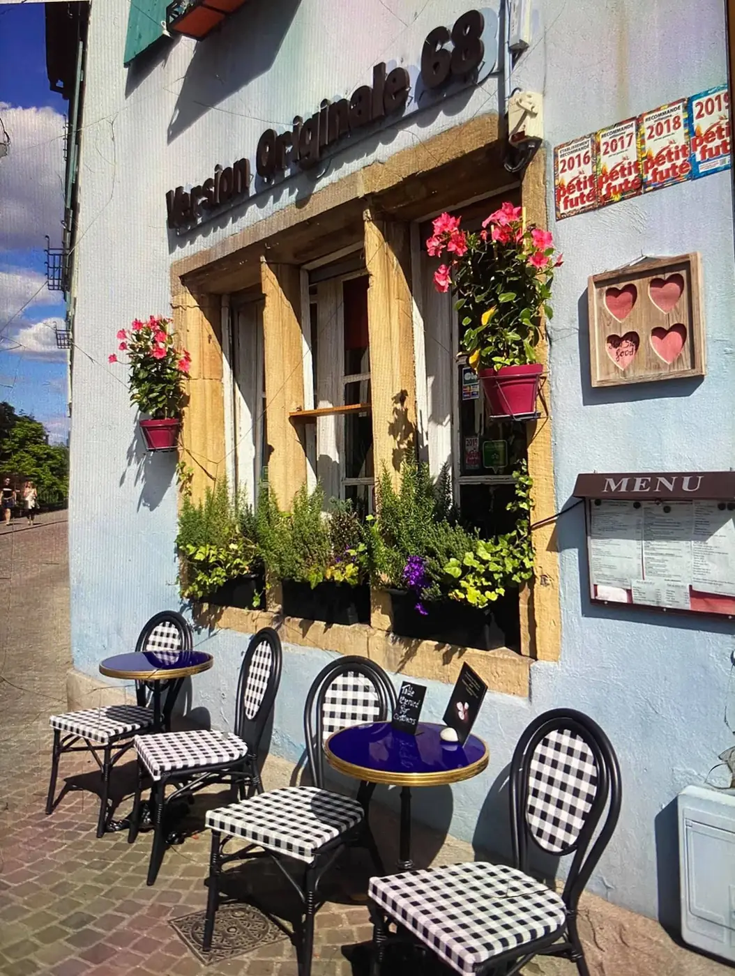 La façade bleue et la terrasse aux chaises à damier, quai de la Poissonnerie
